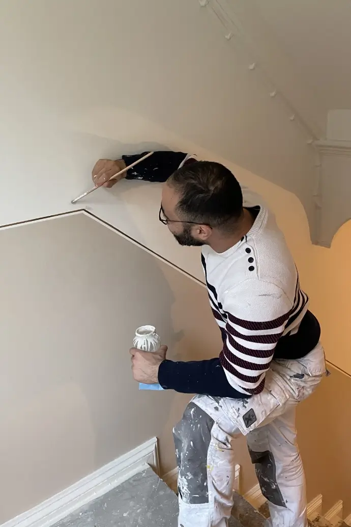 Treppenhaus anstreichen Malermeister Klein Ein Mann beim Anstreichen eines Treppenhauses